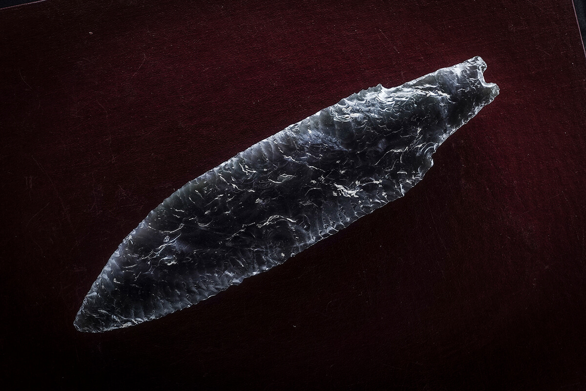 Obsidian spear point on a dark background, preservation photography with the Halumin H18