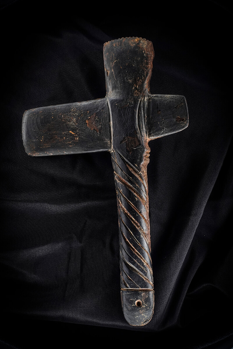 T-shaped carved stone artifact on black fabric, museum artifact photography with the Halumin H18
