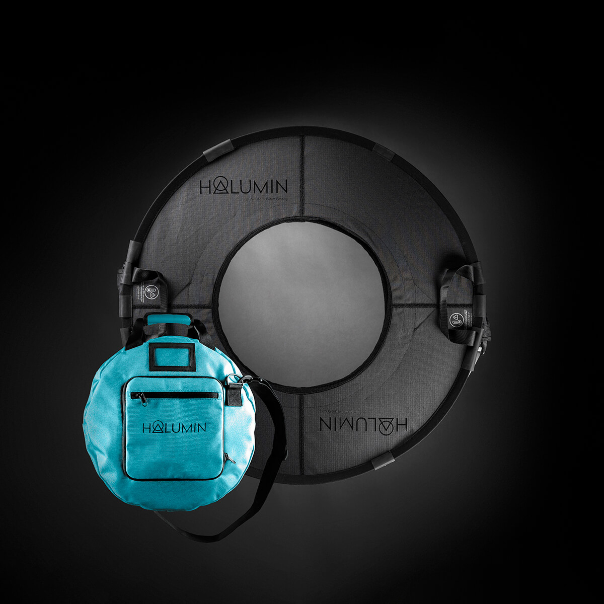 Halumin H18 open cylindrical lighting device with its teal carry case on a black background