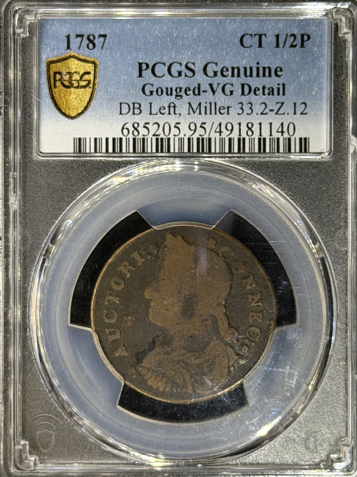 1787 Connecticut copper, Draped Bust Left, Miller 33.2-Z.12, in a PCGS Genuine Gouged-VG Detail holder, photographed with Halumin-C