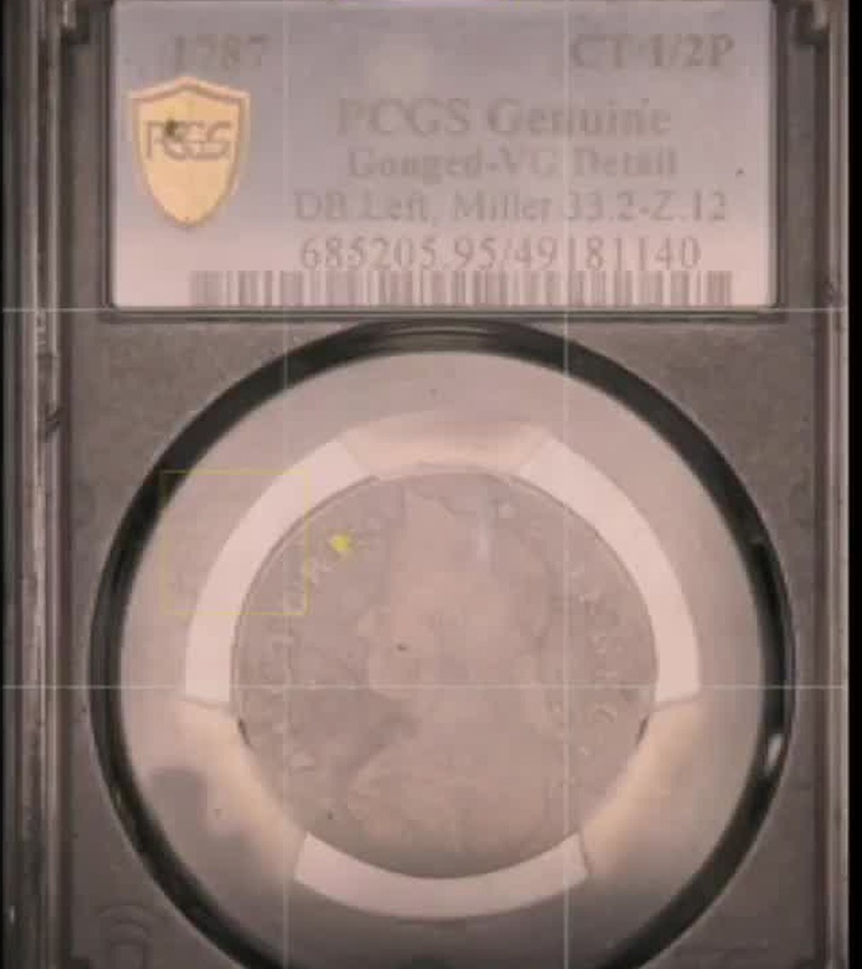 iPhone camera view of a 1787 Connecticut copper in a PCGS slab under axial light only, washed out by slab glare