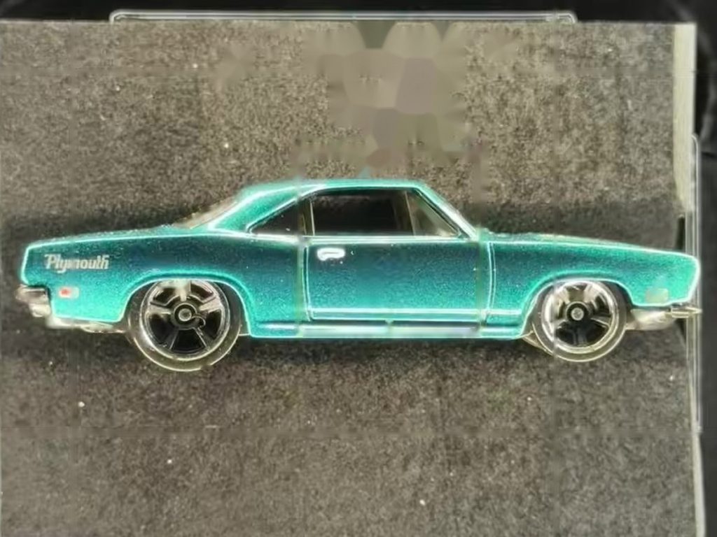 Hot Wheels '68 Plymouth Barracuda in Halumin-C before exposure lock, with a gray backdrop.