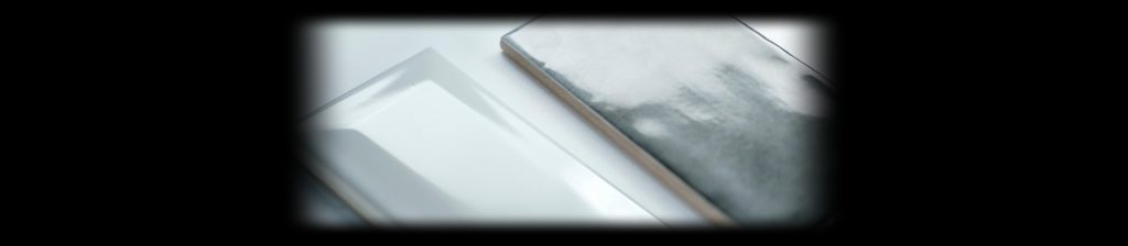 Glossy white beveled and metallic ceramic tiles lit on black for tile product photography with the Halumin H18