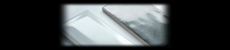 Glossy white beveled and metallic ceramic tiles lit on black for tile product photography with the Halumin H18